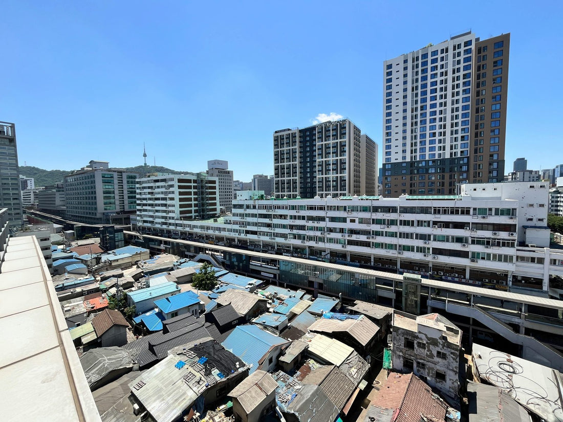 Rooftop view over Ikseon-dong's old tiled roofs with modern Seoul towers and Namsan behind